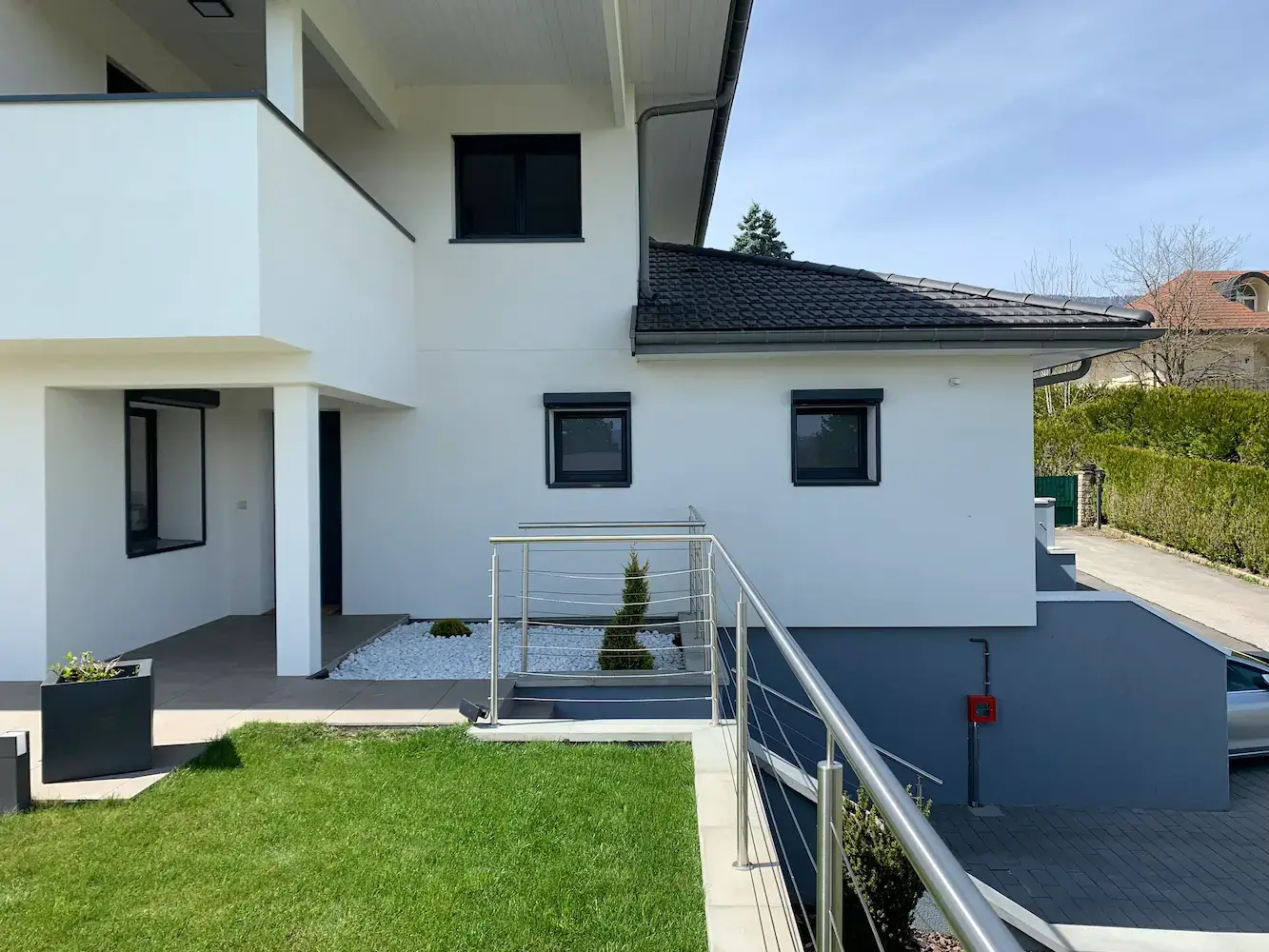Façade jardin après réhabilitation totale — loggia, menuiseries aluminium, terrasse de plain-pied — surélévation Divonne-les-Bains